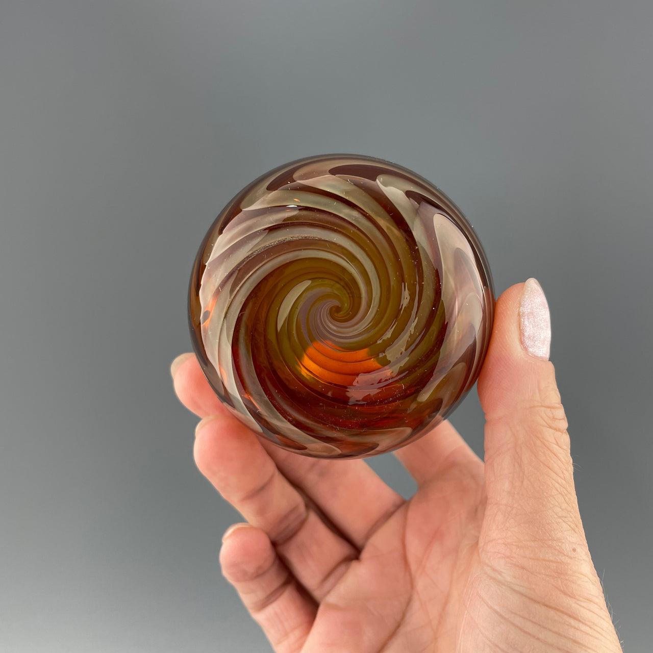 bottom of an amber and silver stemless wineglass