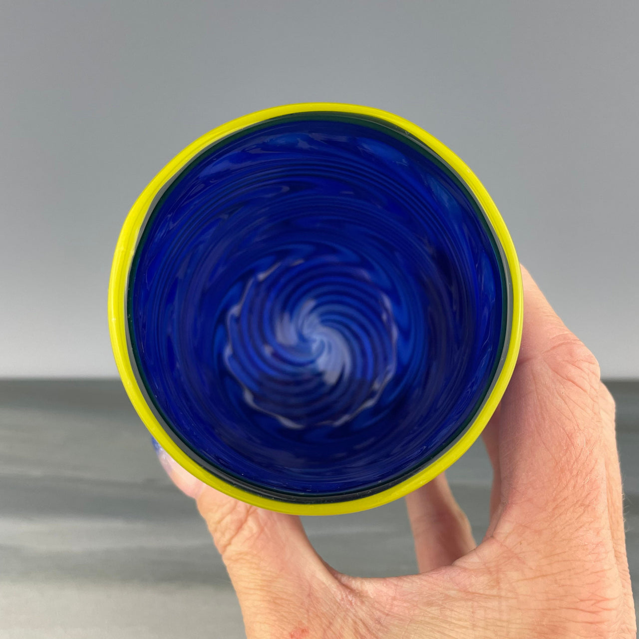 inside of a cobalt blue cup with a yellow rim