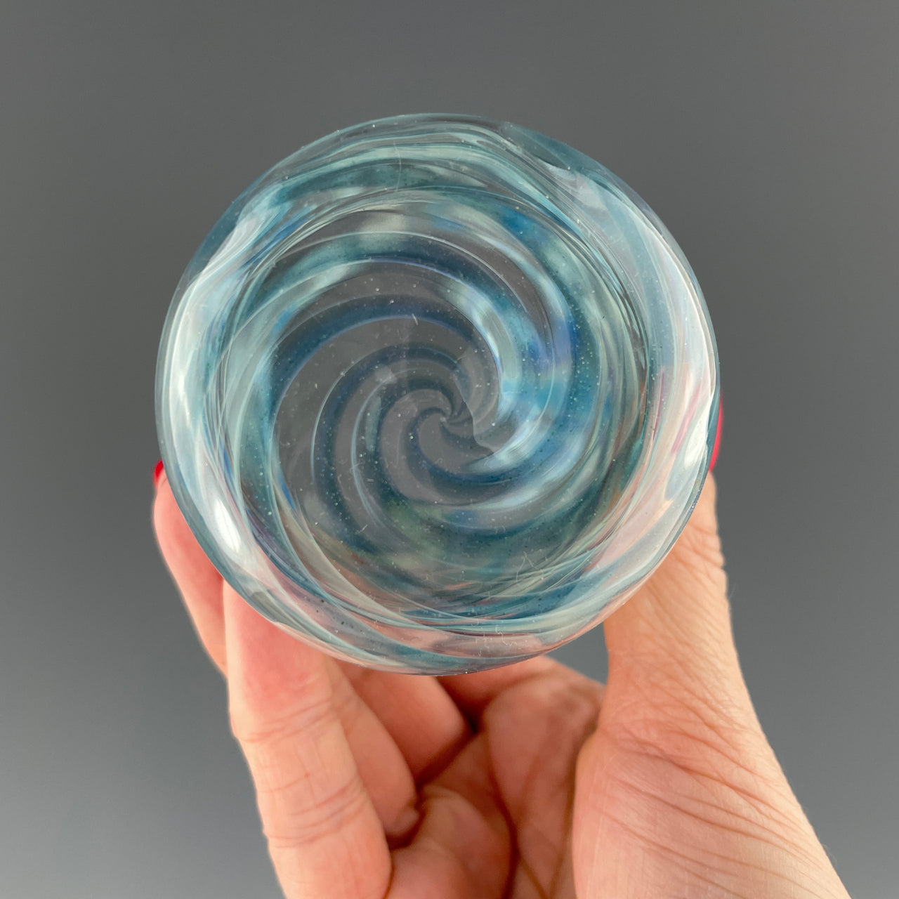 bottom of a clear and blue sparkle swirls cup