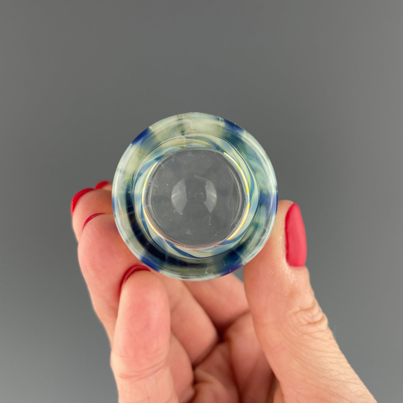 bottom of a clear and blue swirls shot glass