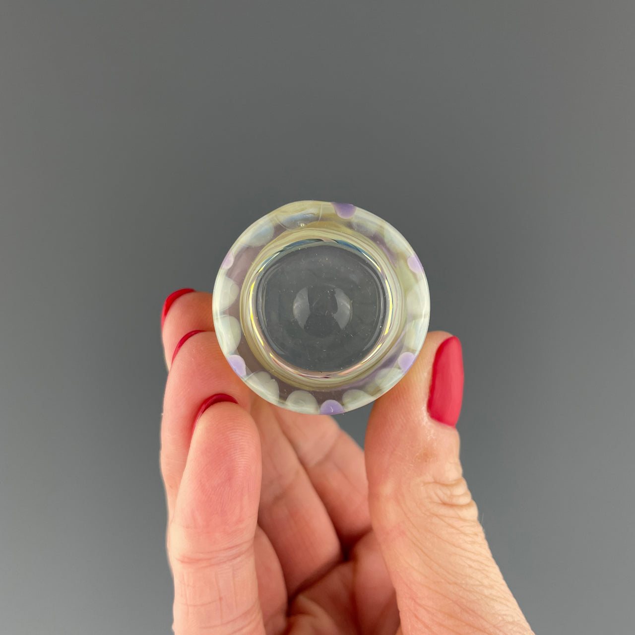 bottom of a clear and purple swirls shot glass