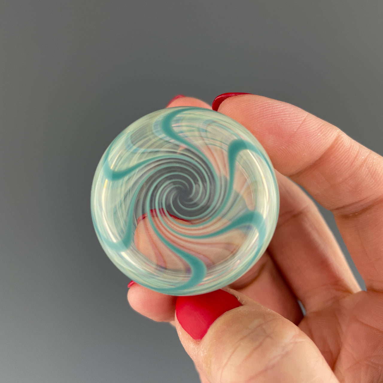 bottom of a clear and teal swirl shot glass