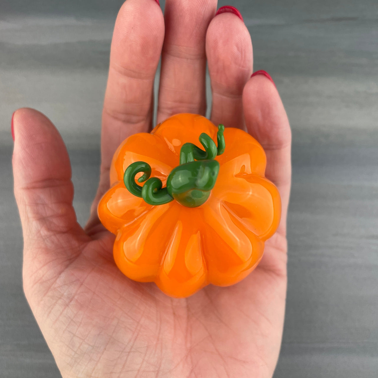 glass pumpkin in the palm of a hand