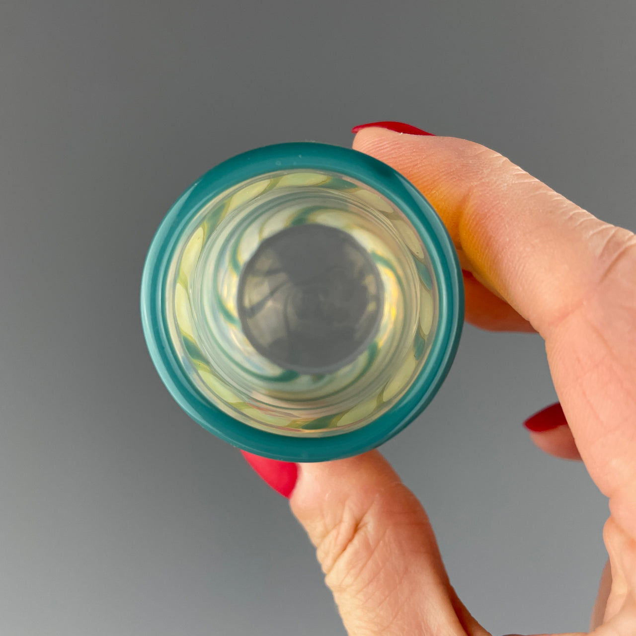 inside of a clear and teal swirl shot glass