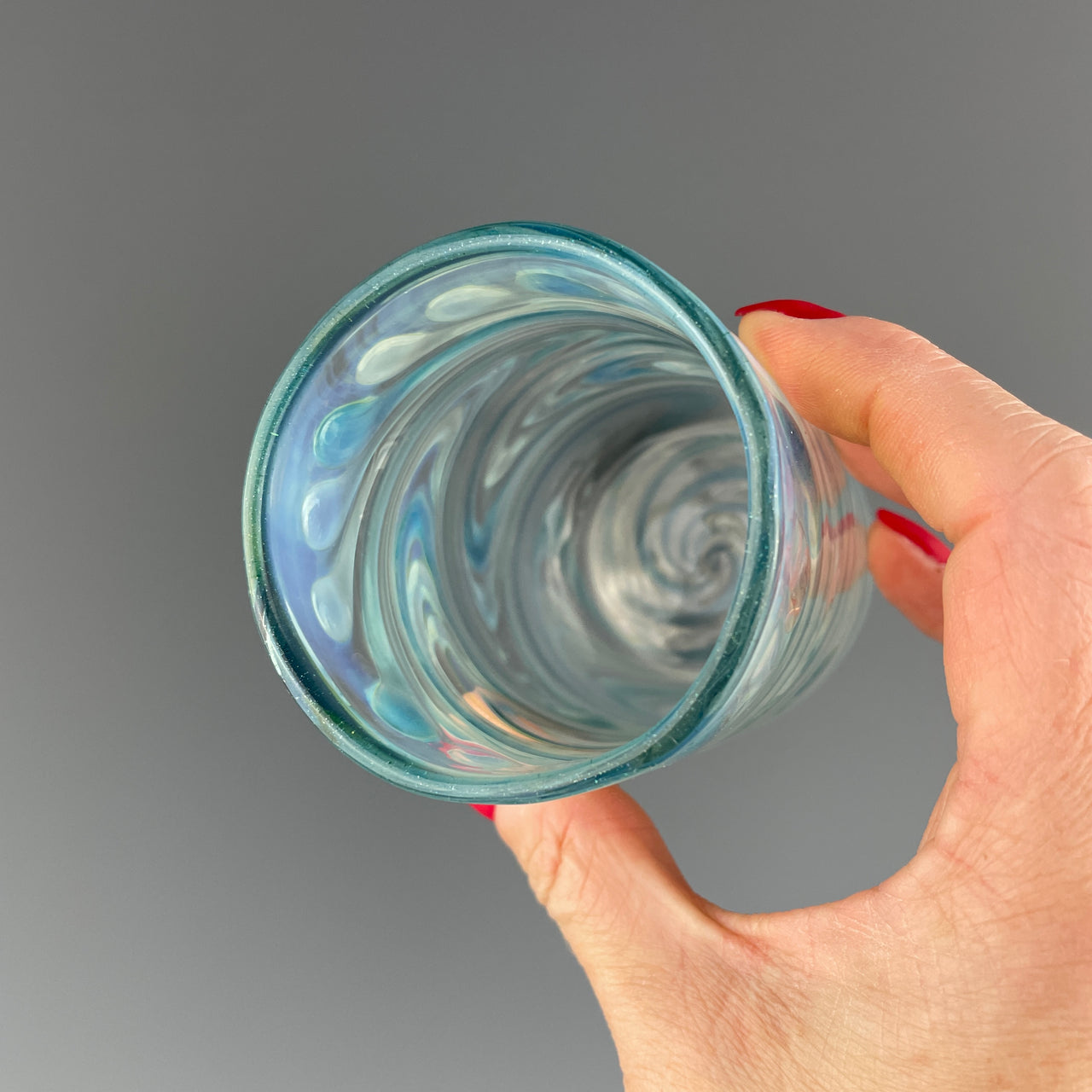 rim of a clear and blue sparkle swirls cup