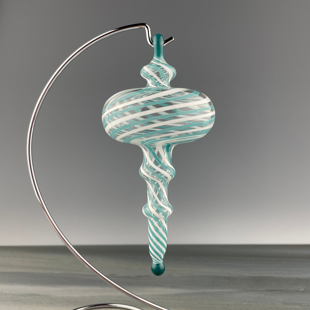 clear glass ornament with a teal and white swirl